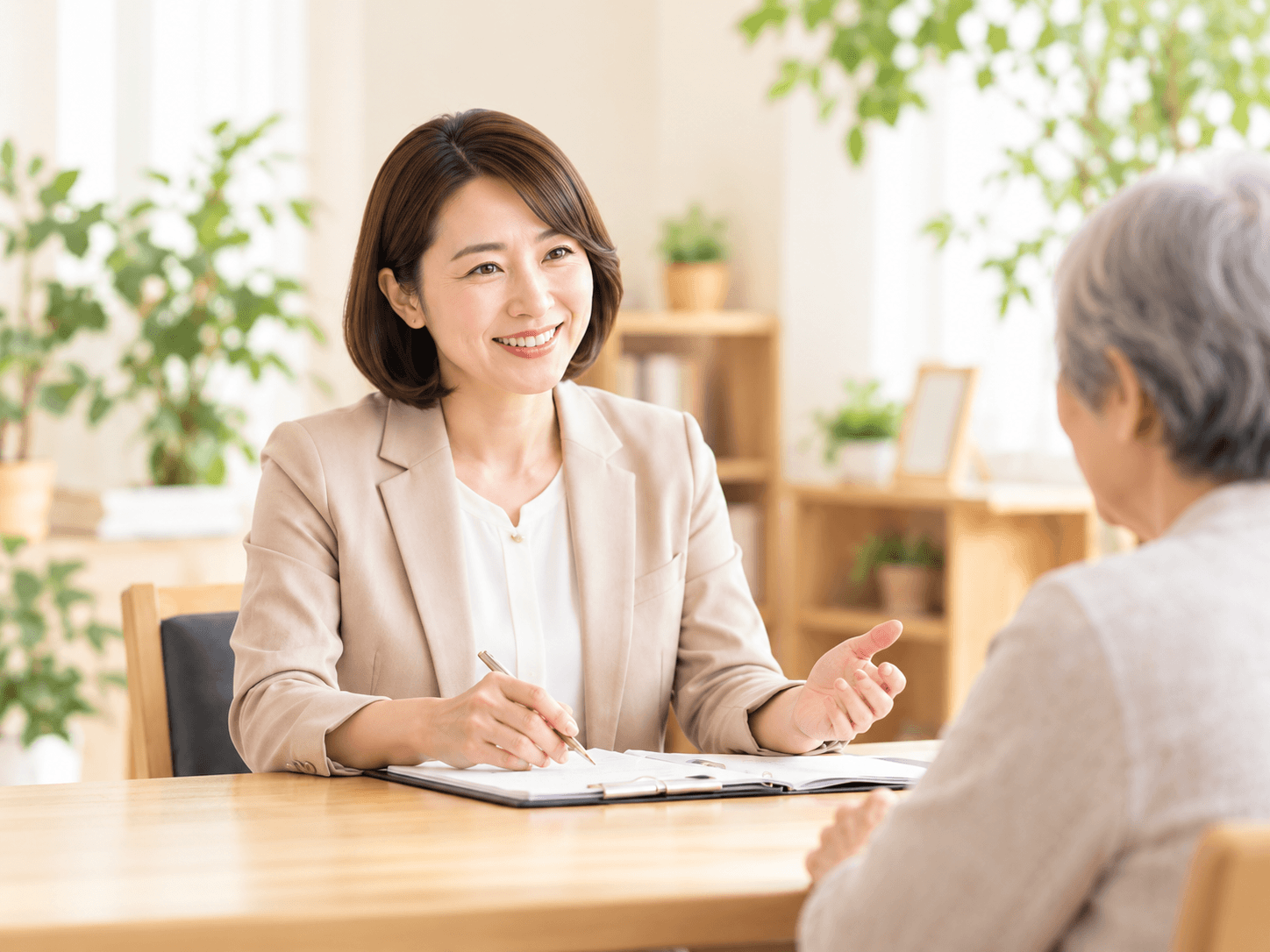 明るい相談室で相談者の話を丁寧に伺う女性行政書士